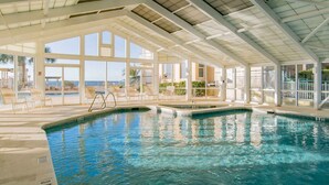 A large indoor swimming pool with clear views of the beach and palm trees. - Beach Colony Towers by Southern Vacation Rentals (Pensacola)