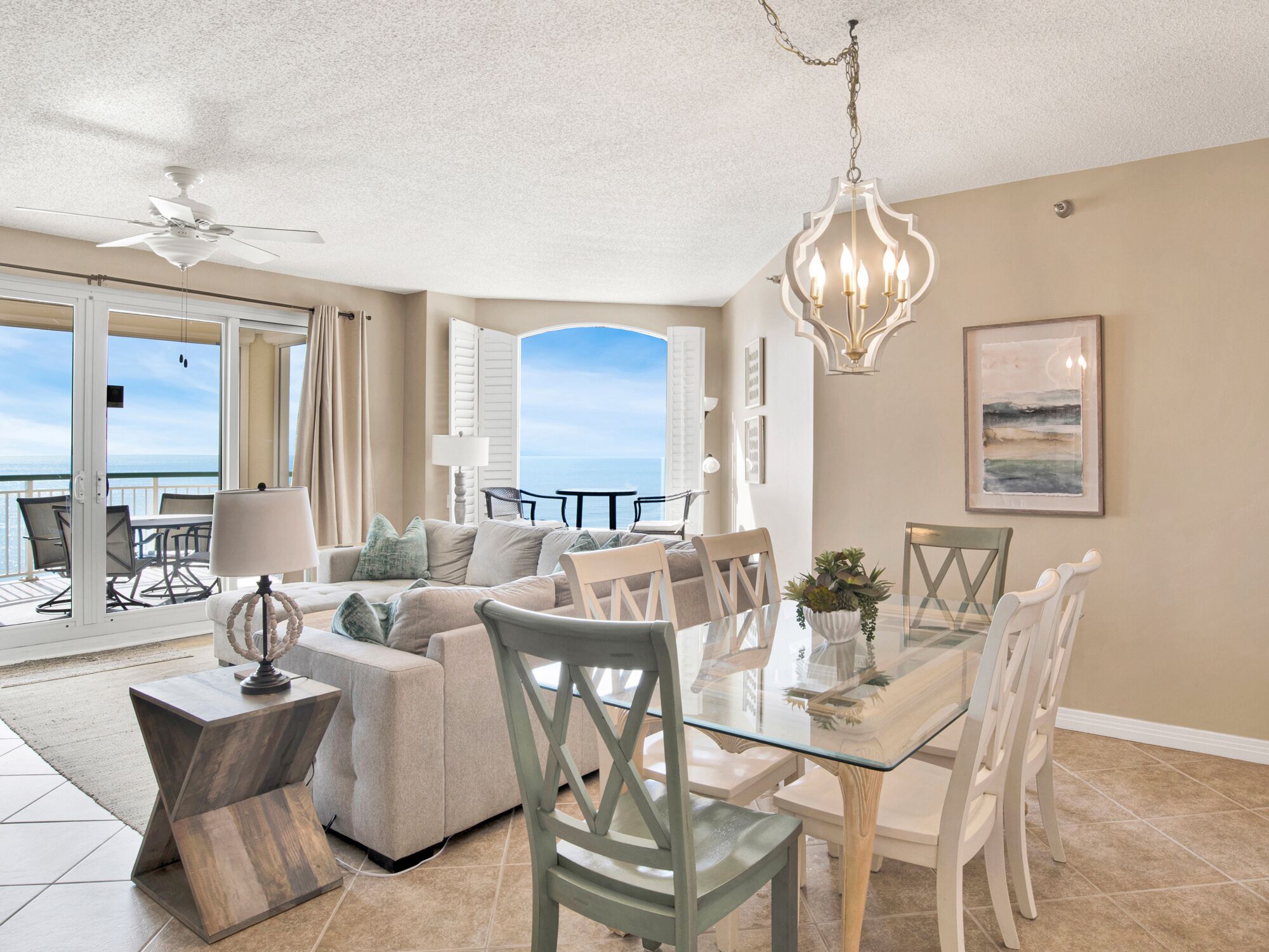 Amplia sala de estar con mesa de comedor de vidrio, asientos cómodos y vista al océano.