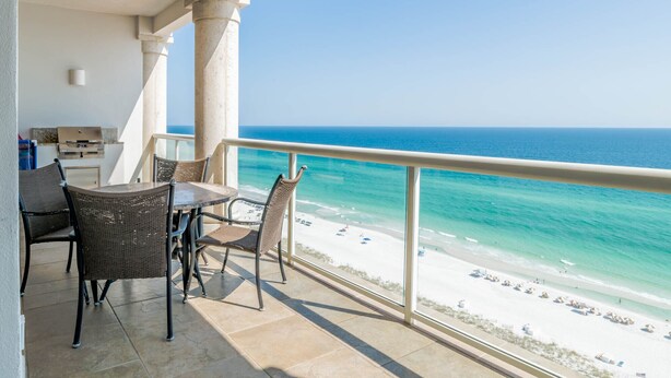 A balcony with a view of the ocean and beach, featuring wicker furniture and a grill. - Beach Club by Southern Vacation Rentals (Pensacola Beach)