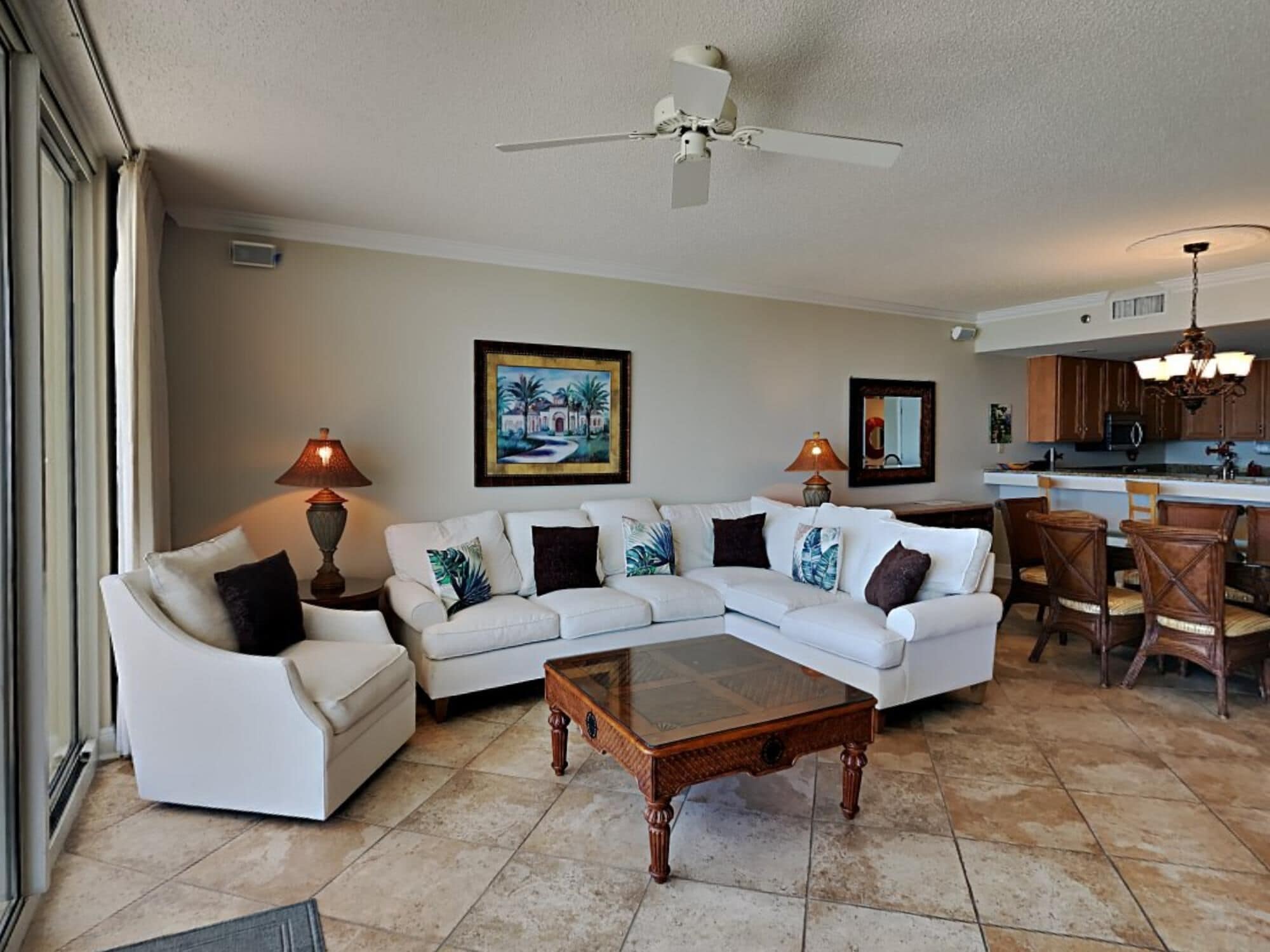 A living room with a sectional sofa, a coffee table, and a ceiling fan.