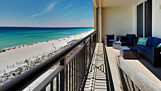 Ein Balkon mit Blick auf Strand und Meer.