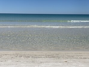 A beach with clear water and a sandy shore.