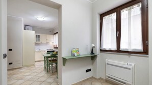 A kitchen with a window, a radiator, and a green chair.