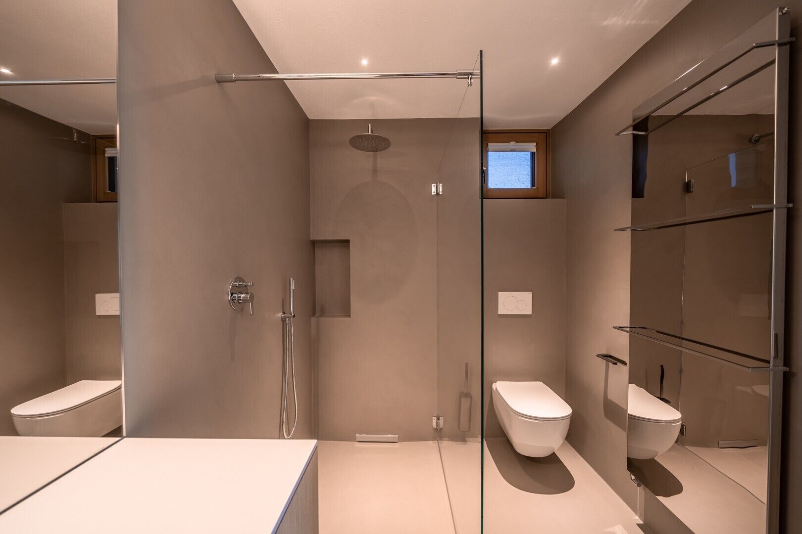Une salle de bain moderne avec une douche à parois de verre, des toilettes et un bidet.
