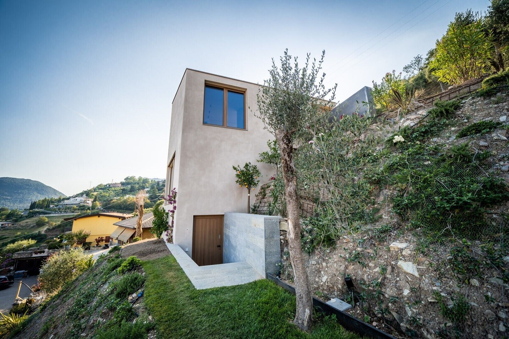 Un bâtiment moderne doté d’un toit plat, d’une grande fenêtre et d’une porte.