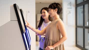 Two people interacting with a digital kiosk in a modern indoor setting.