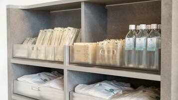 A storage unit with neatly organized compartments containing toiletries and folded towels.