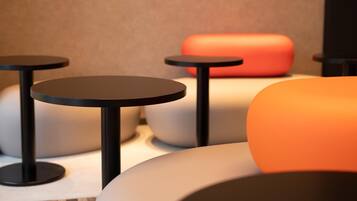 A modern seating area with round tables and cushioned seating.