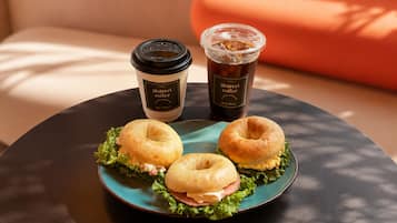 A table with two coffee cups and two sandwiches.
