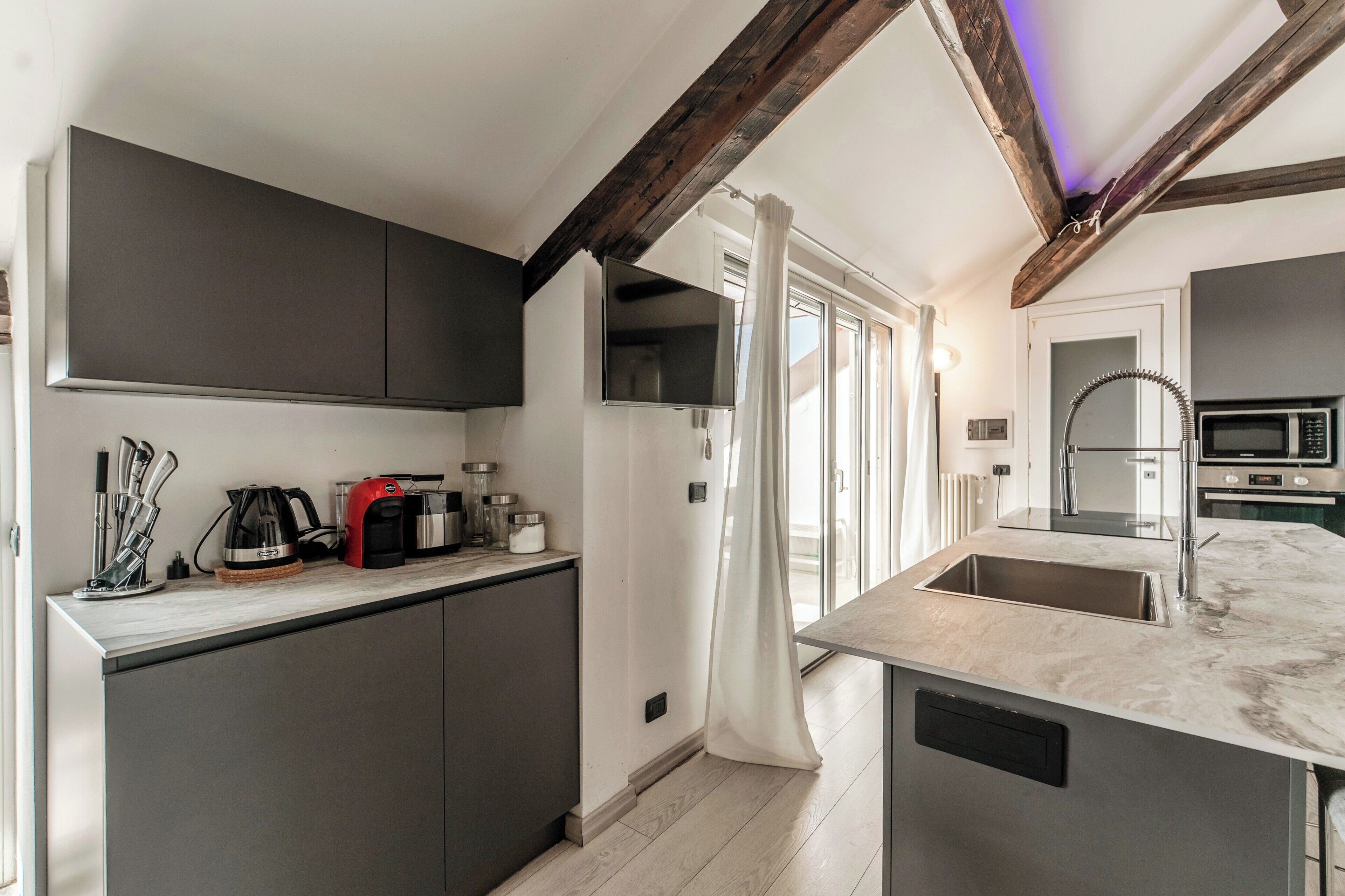 A modern kitchen with a built-in island, stainless steel appliances, and a pendant light.