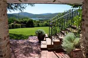 Un sendero de piedra que conduce a una escalera con vistas a un jardín exuberante y un lago.