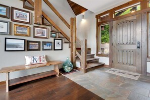 Una escalera con vigas de madera, un banco y una puerta con pomo metálico.