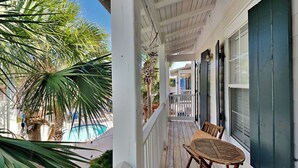 A wooden deck with a pool, palm trees, and a view of the pool area. - Bungalows at Seagrove by Southern Vacation Rentals (Santa Rosa Beach)