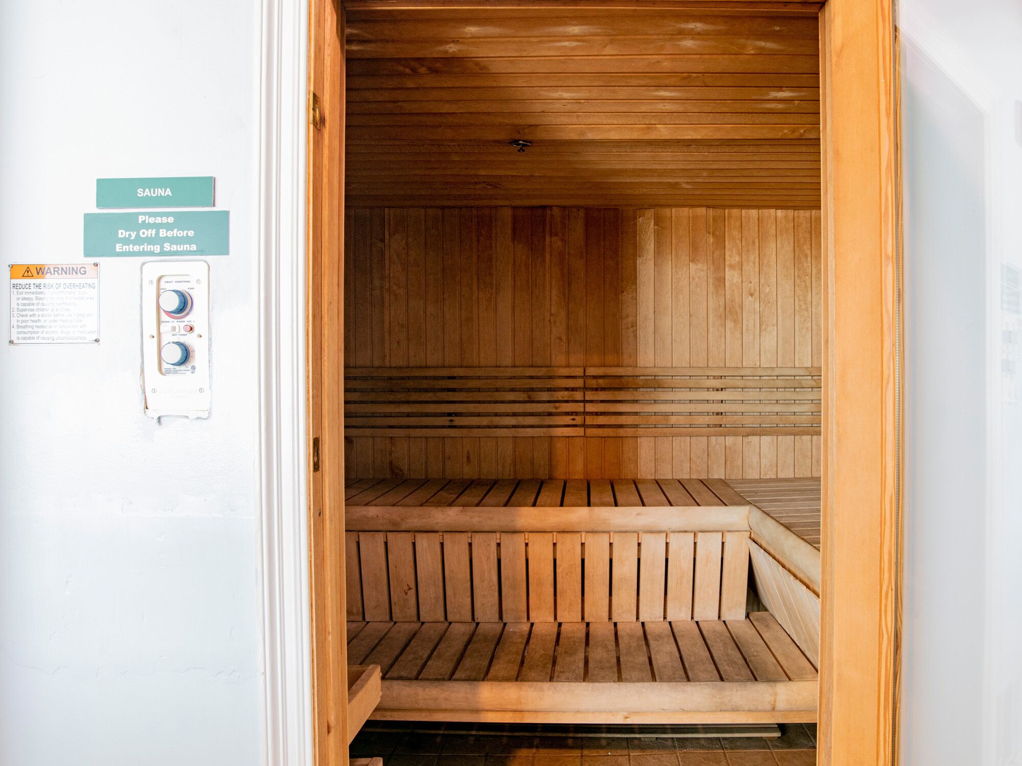 Una sauna con bancos de madera y un panel de control.