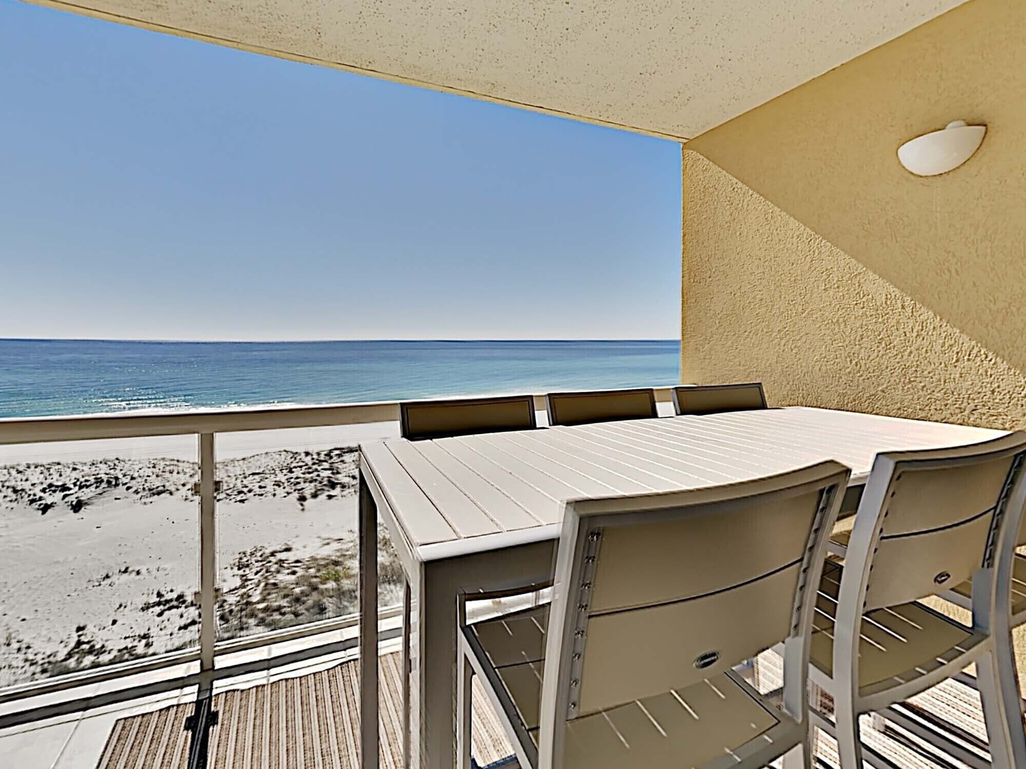 Un balcon avec vue sur la plage et l’océan.