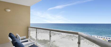 A balcony with a view of a beach and ocean.