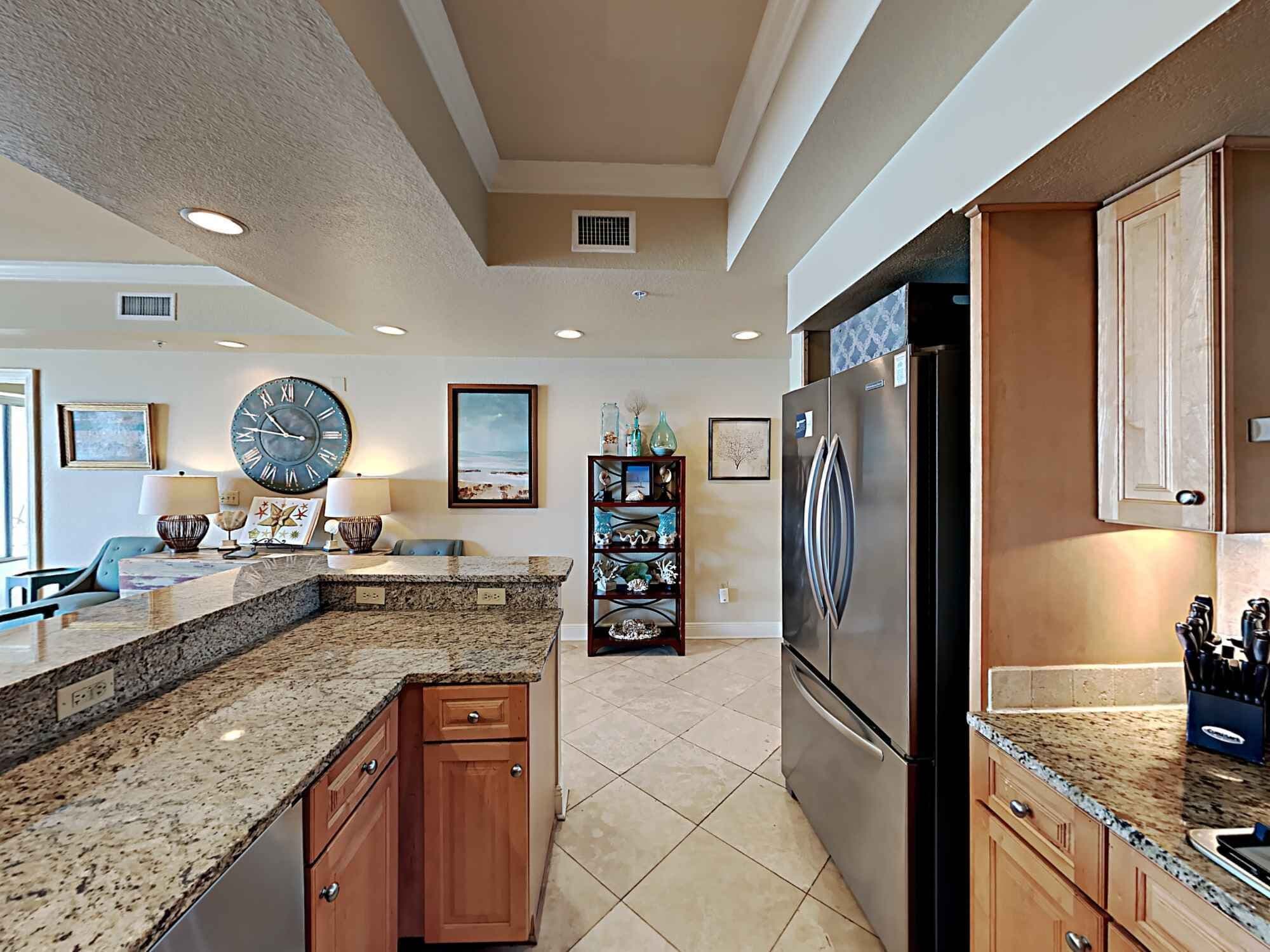 A modern kitchen with granite countertops, stainless steel appliances, and wooden cabinetry.