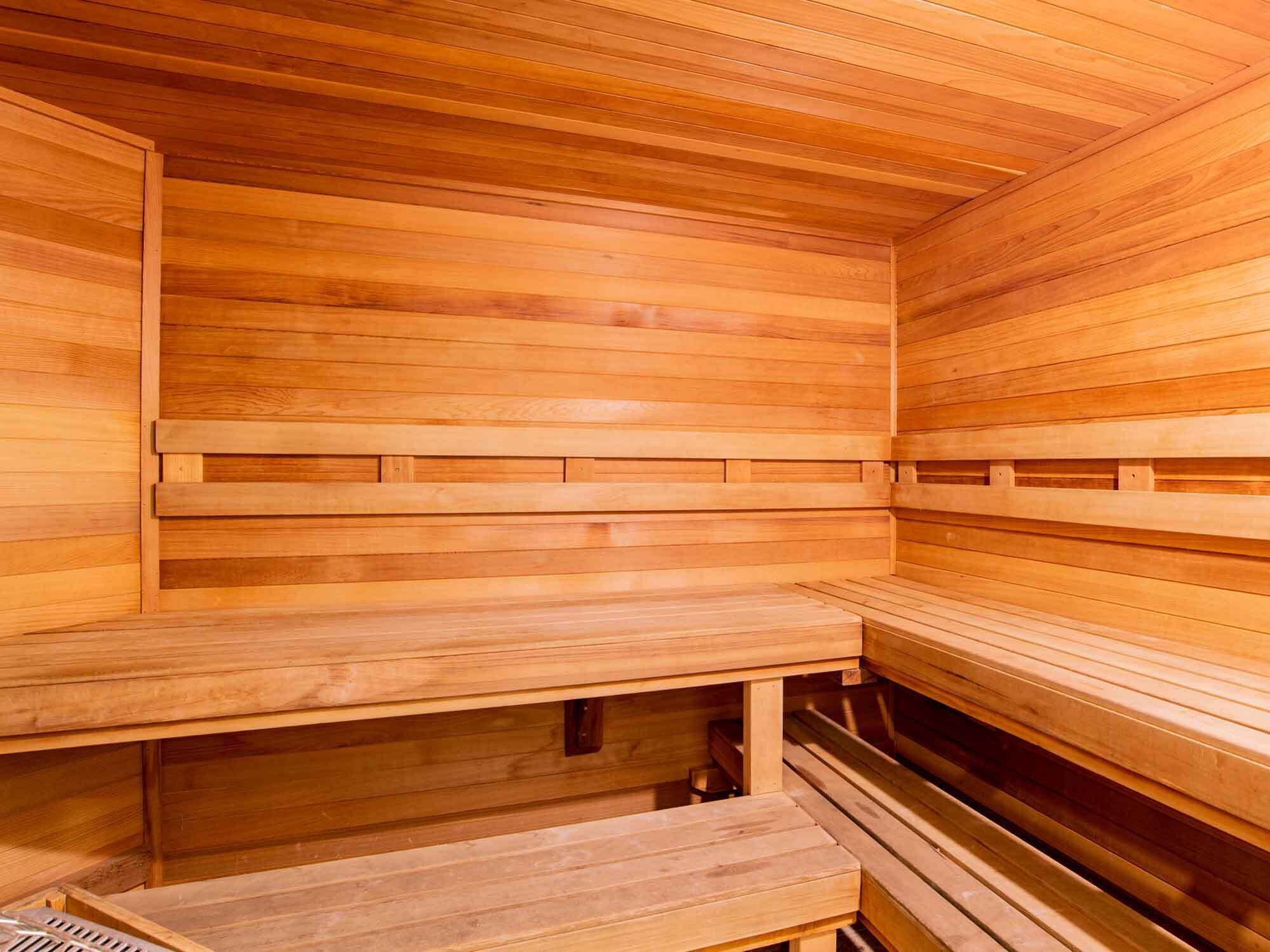 Una sauna de madera con bancos y un asiento.