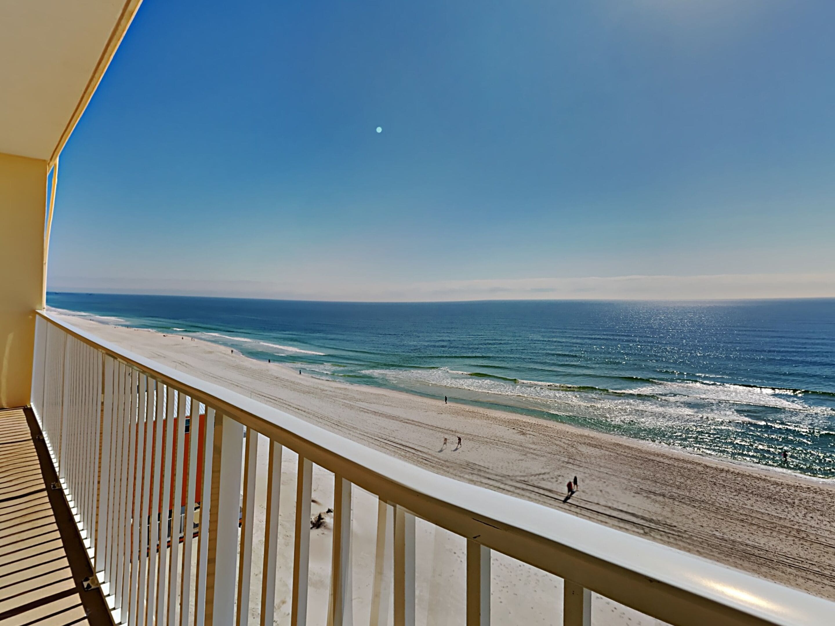A balcony with a view of a beach and ocean.