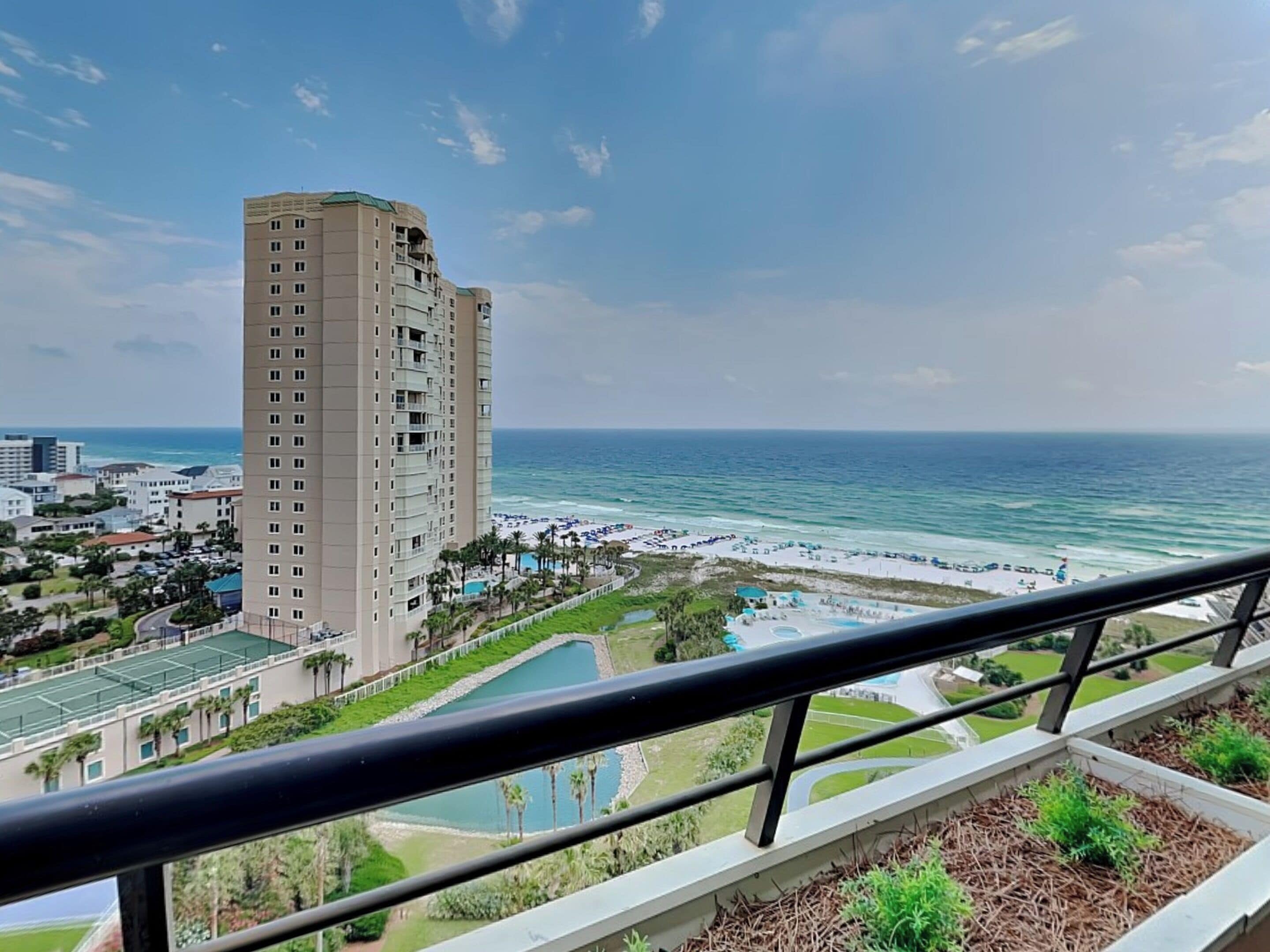 A high-rise hotel with a view of the ocean and beach.