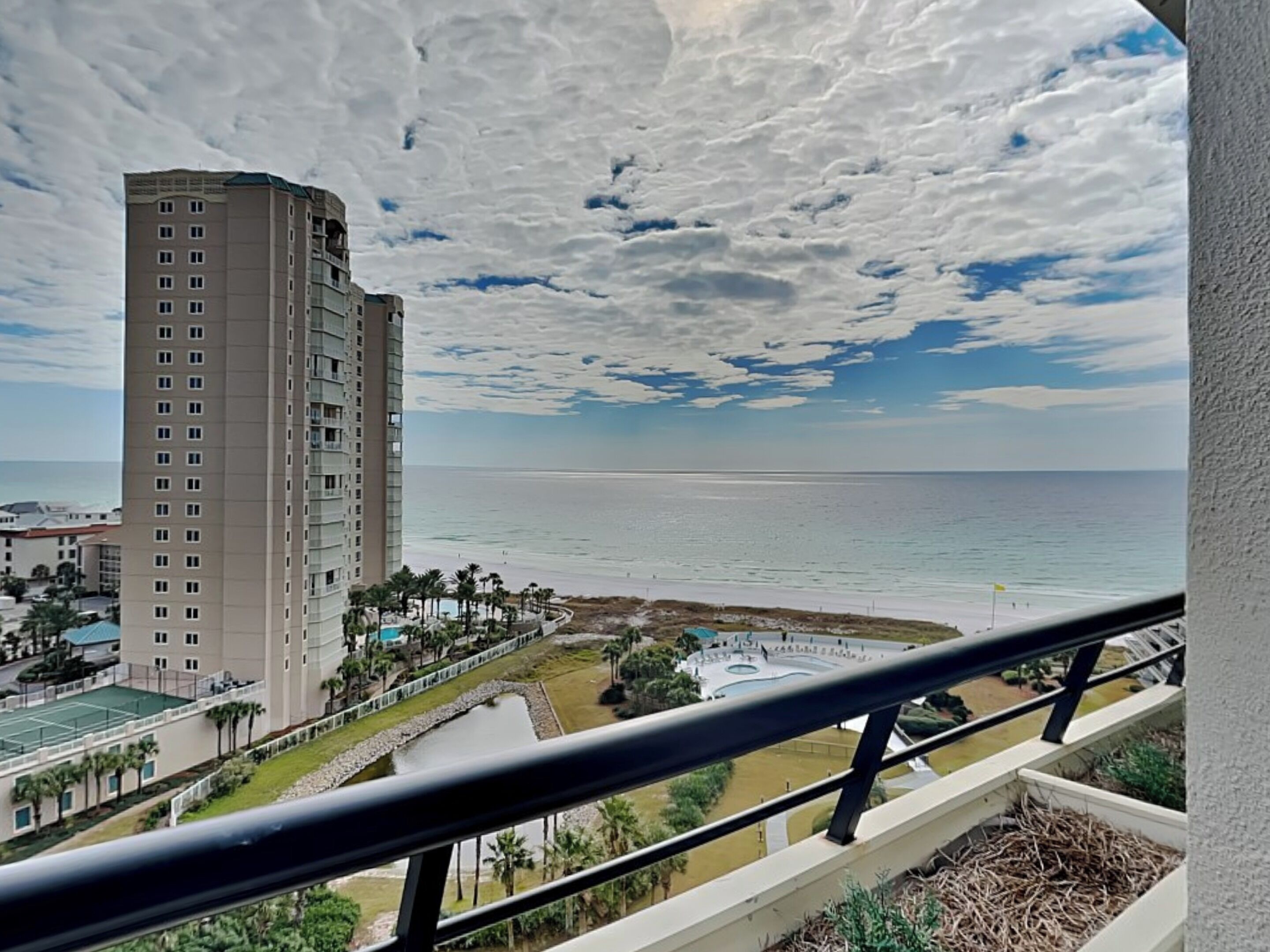 A high-rise hotel with a view of the beach and ocean.