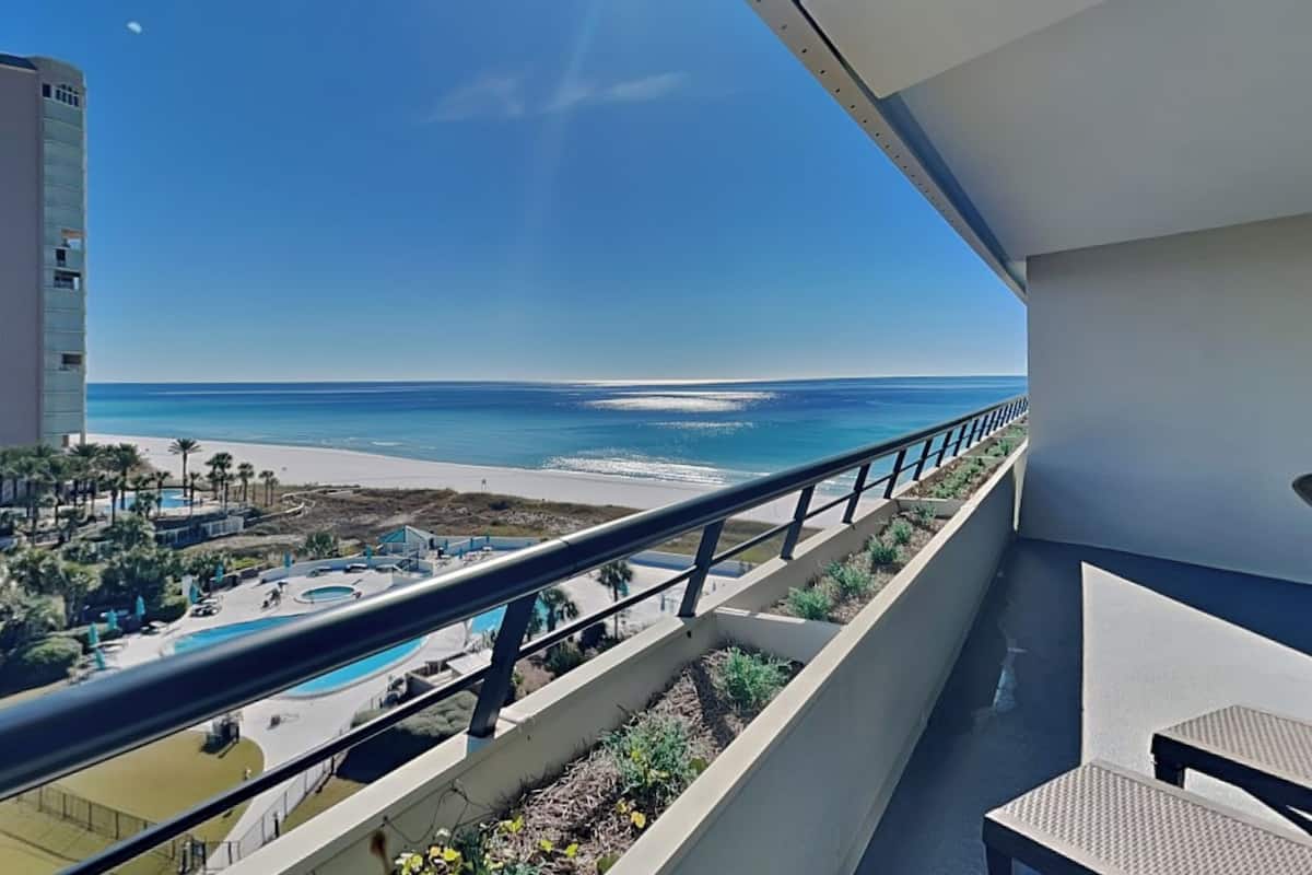A balcony with a view of a beach and ocean.
