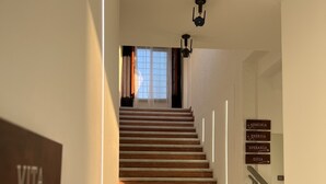 A staircase with wooden steps and white railings, leading to a room with a window and a sign reading "VITA". - Abitatt (Fosdinovo)