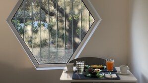 A dining area with a table set for breakfast, including a glass of orange juice, a cup, and a plate with food. - Abitatt (Fosdinovo)