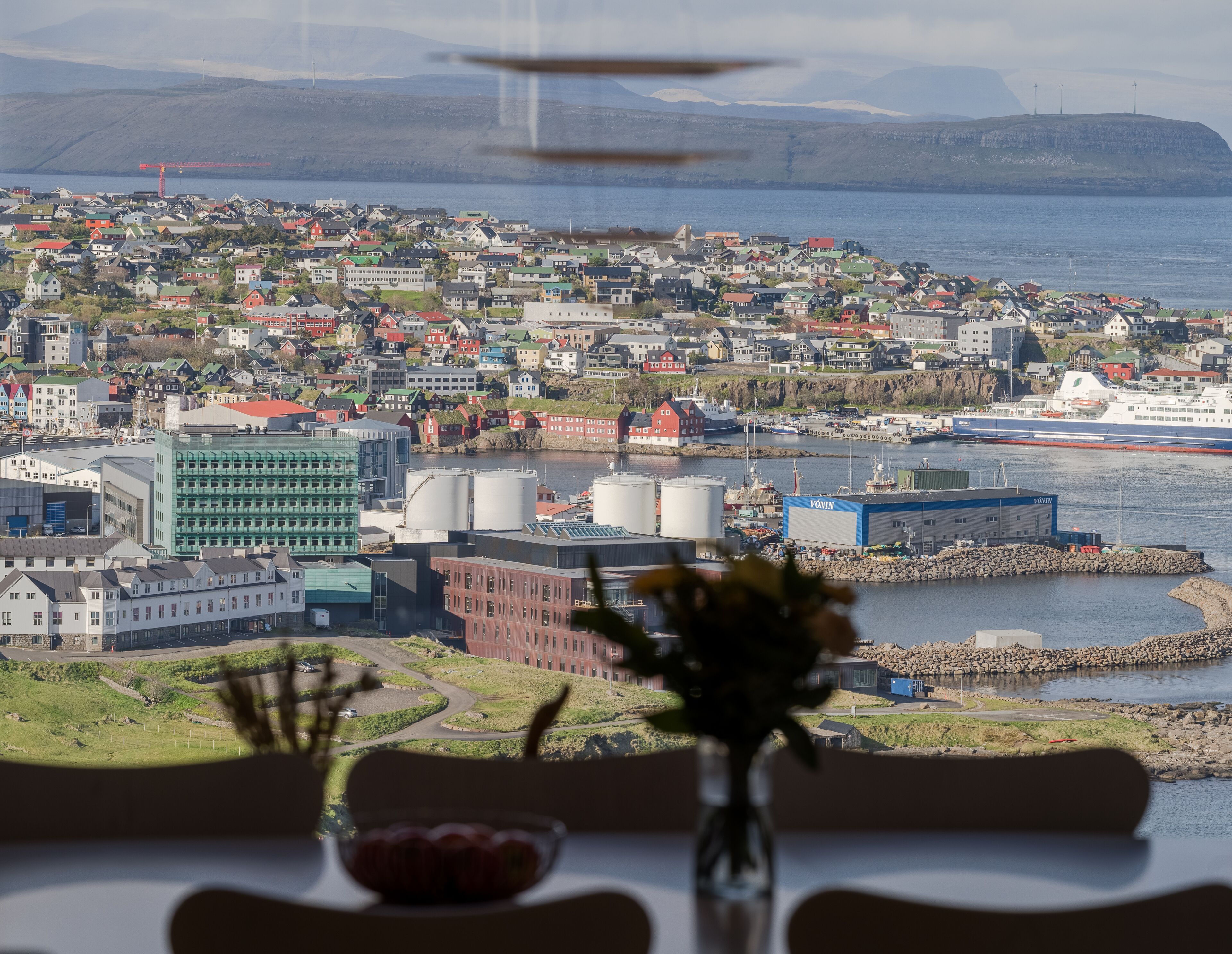 A coastal town with a view of the sea and mountains in the background.