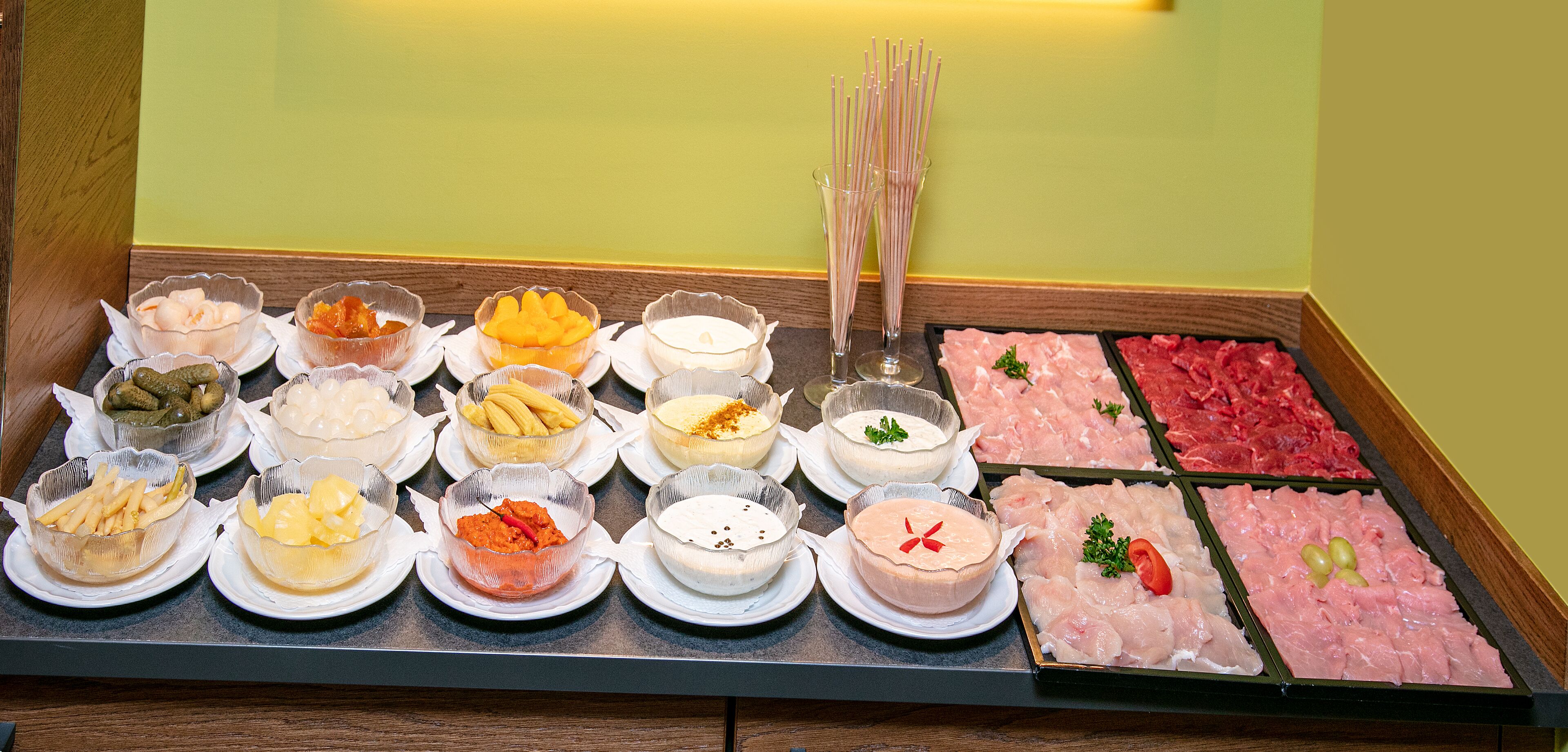 A buffet with various dishes including seafood, fruits, and condiments.