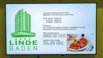 A signboard with the logo of 'LINDE BADEN' and details of restaurant hours and locations.