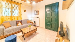 Un salon avec un canapé, une table basse et un téléviseur.