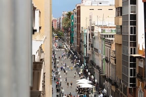 Une rue animée en milieu urbain, avec des piétons, des immeubles et des lampadaires.
