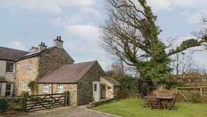 Una casa de piedra con camino de grava y una puerta de madera.