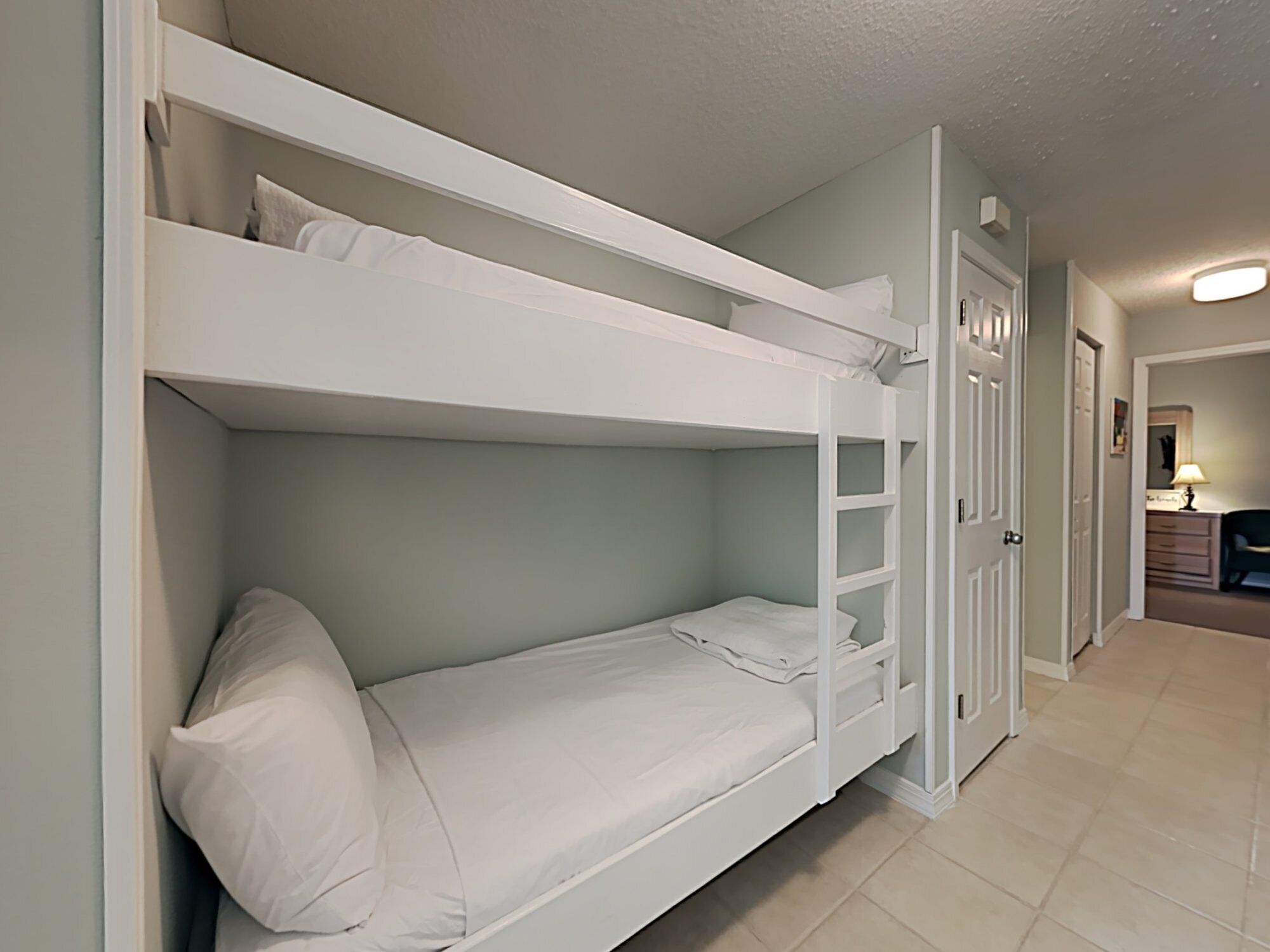 A bunk bed with a lower bunk and a door to a hallway.