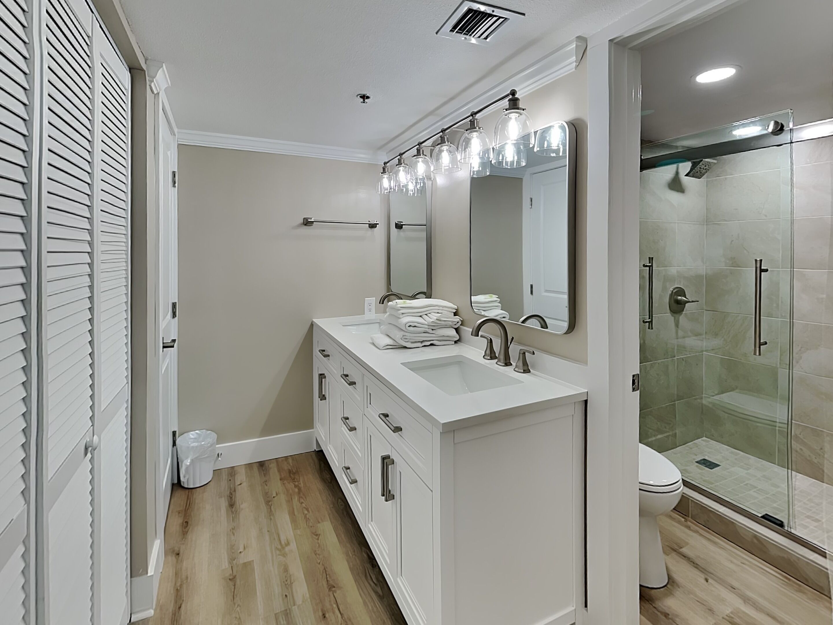 Un baño moderno con tocador, lavamanos y espejo.