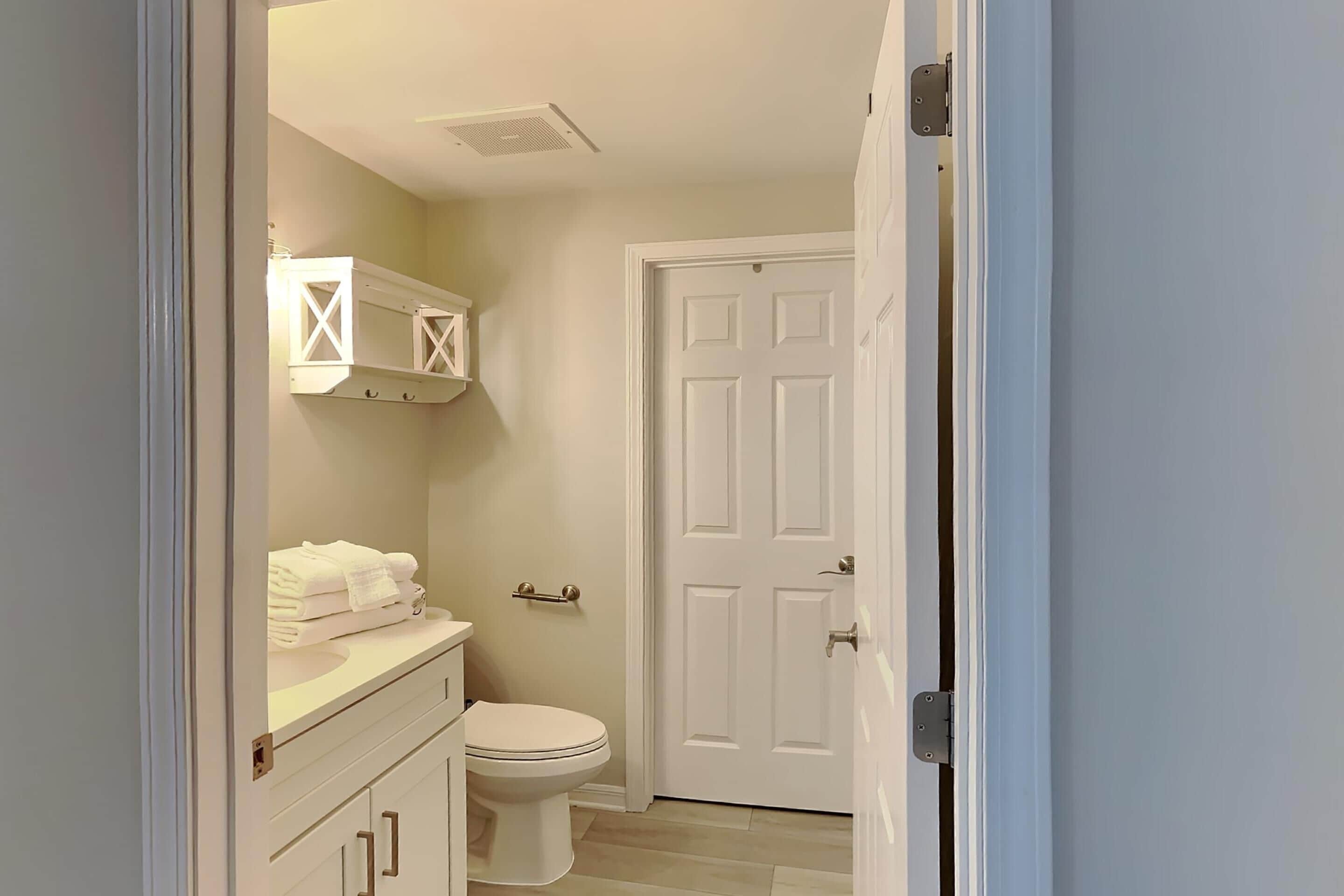 A bathroom with a toilet, a sink, and a cabinet.
