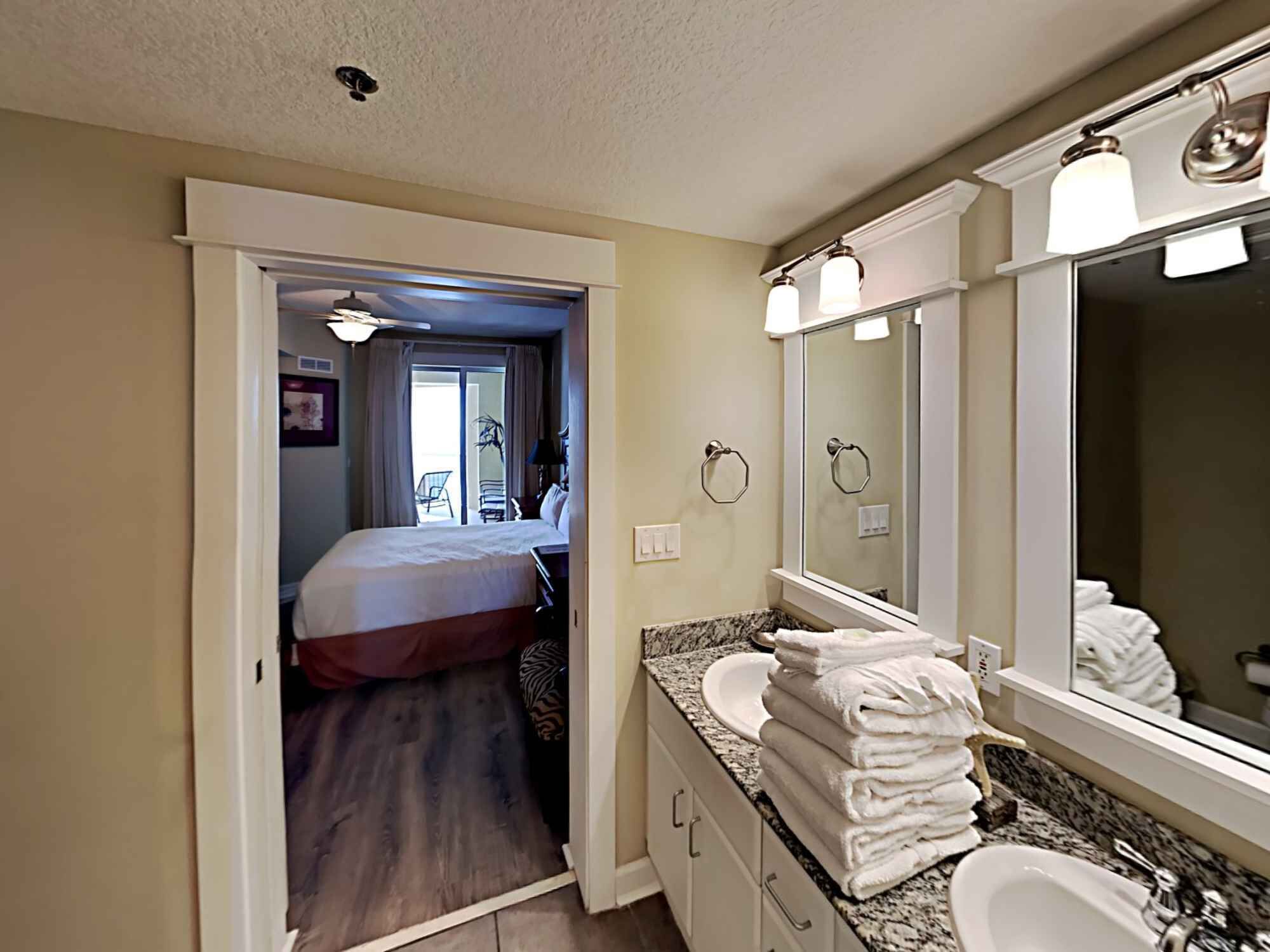 Une salle de bain d’hôtel avec un grand miroir, un lavabo et des toilettes.