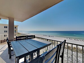 Enjoy stunning ocean views from this balcony with a table and chairs.