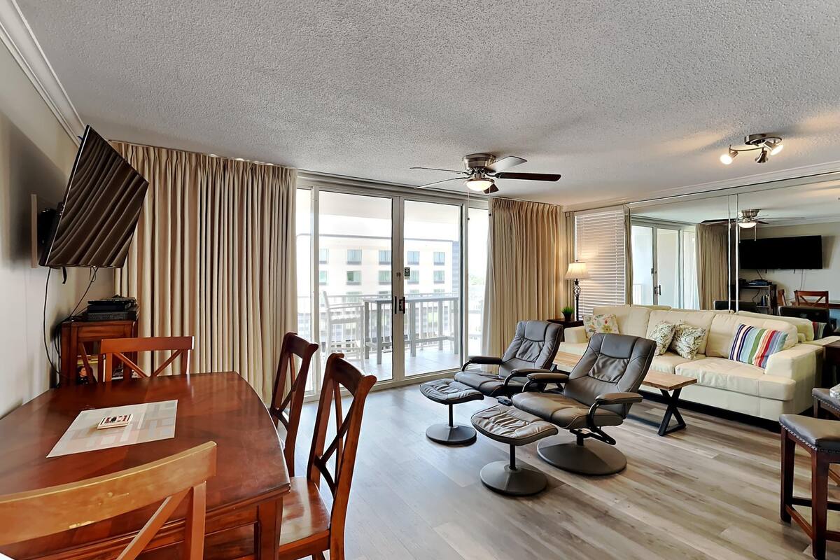 Ein Hotelzimmer mit Esstisch, Stühlen, einer Couch und einem Fernseher.