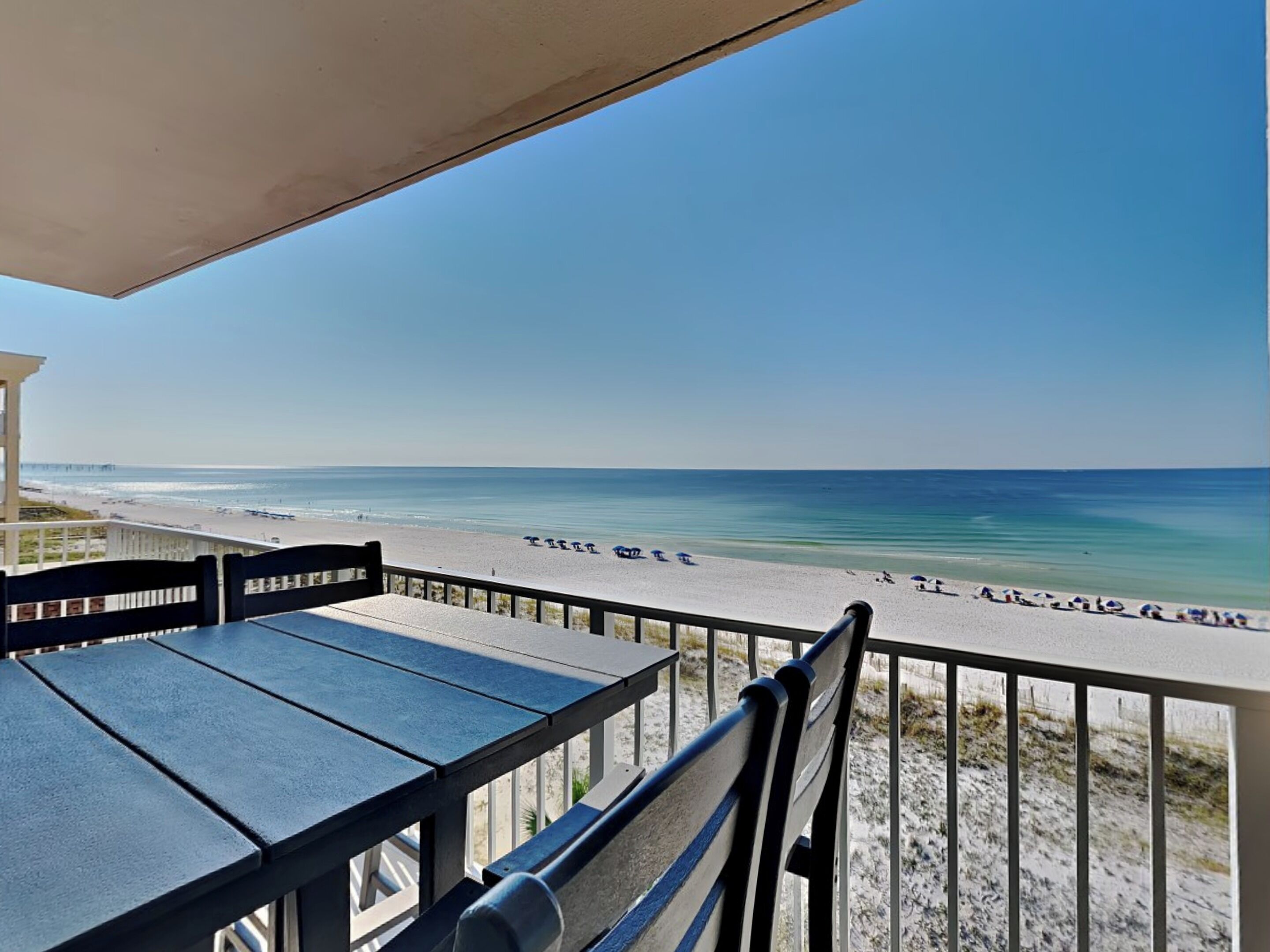 Un balcon avec vue sur une plage et l’océan.