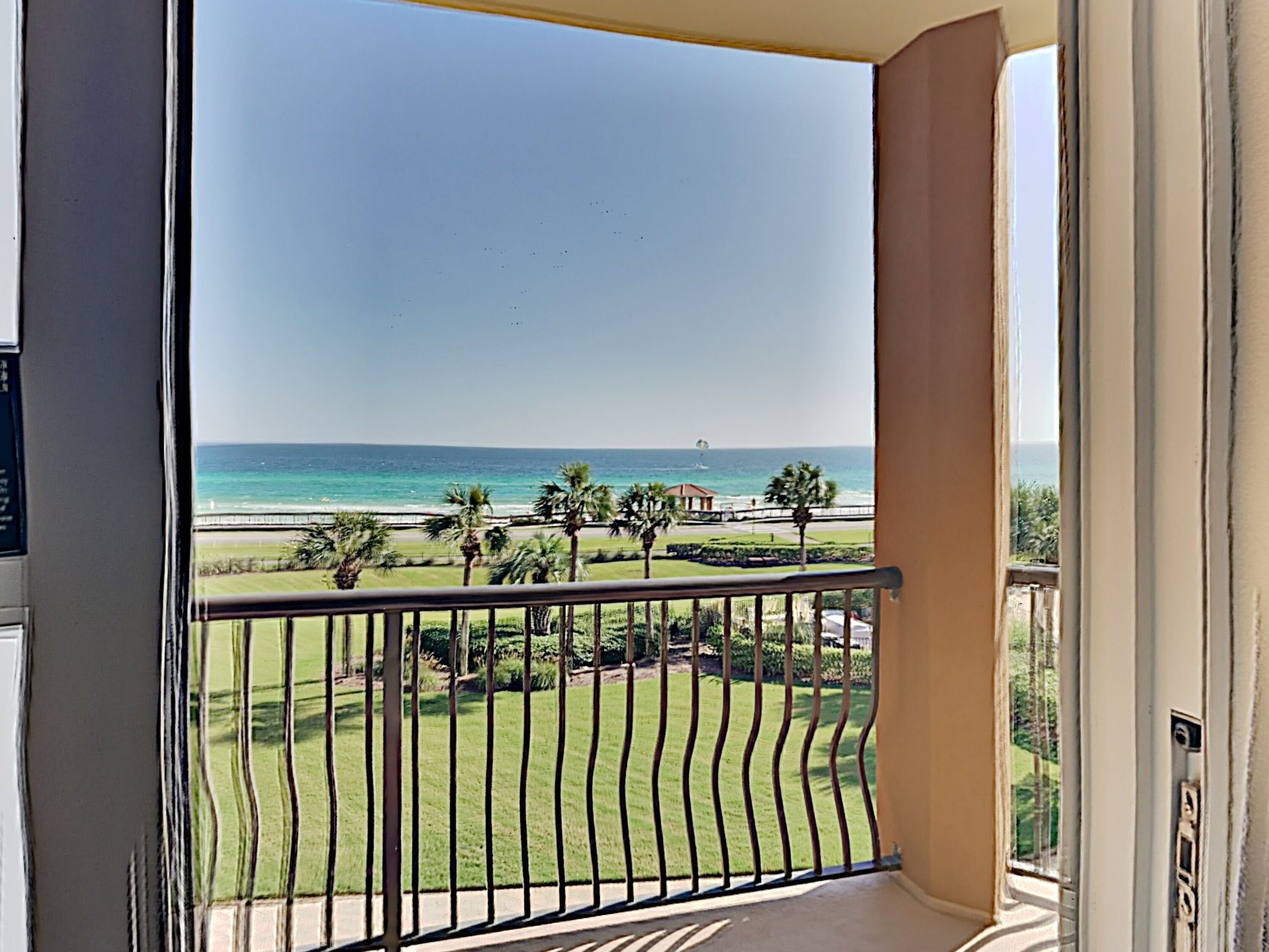 A balcony with a view of the beach and ocean.