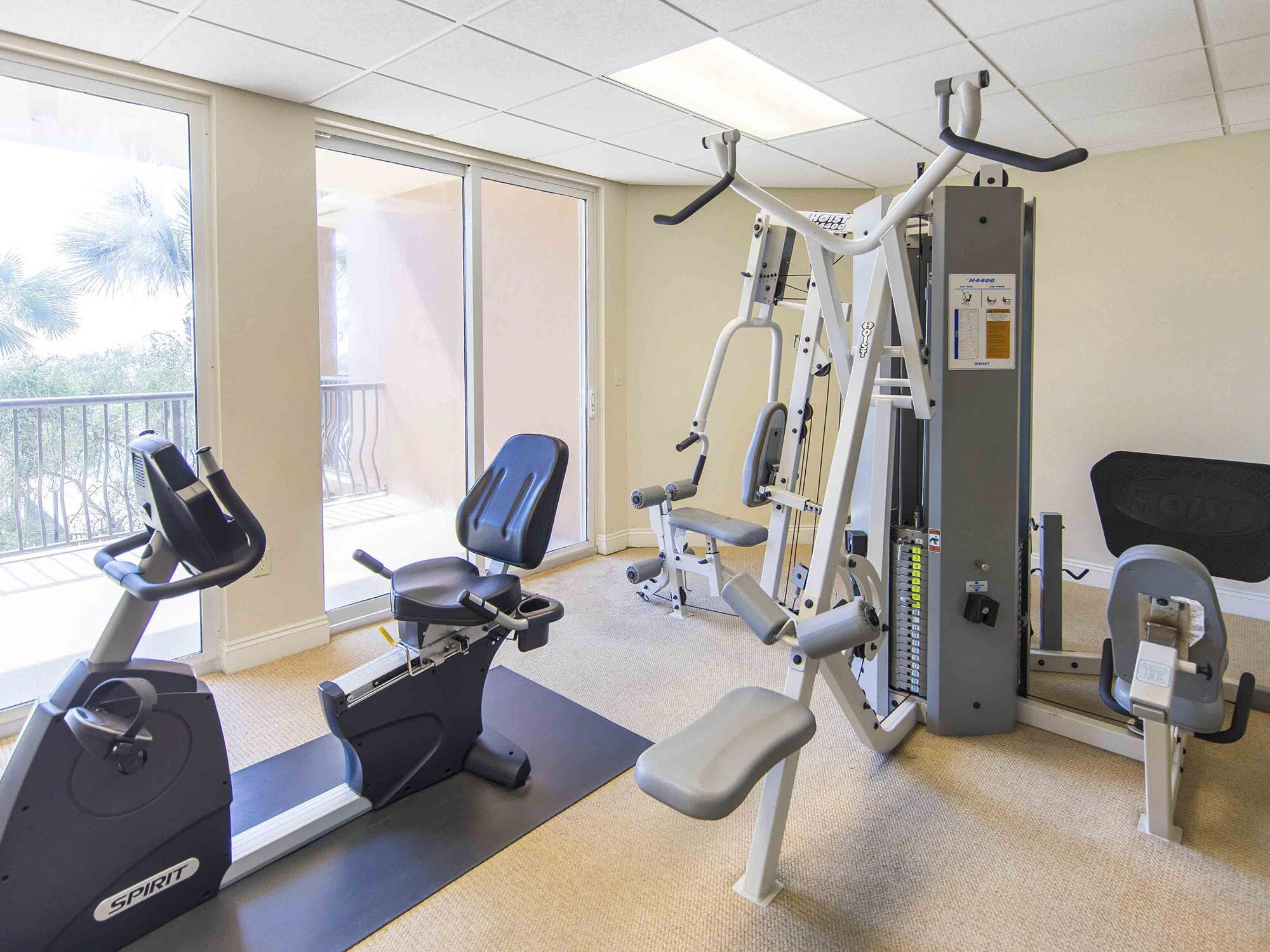 A gym with cardio equipment, weight machines, and a bench.