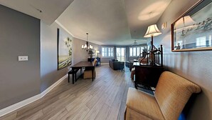 A spacious living area with a dining table, a piano, and a comfortable seating area. - Mediterranea by Southern Vacation Rentals (Miramar Beach)