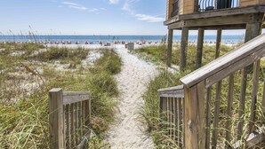 A wooden pathway leading to a beach with beach umbrellas and a lifeguard tower. - Mediterranea by Southern Vacation Rentals (Miramar Beach)