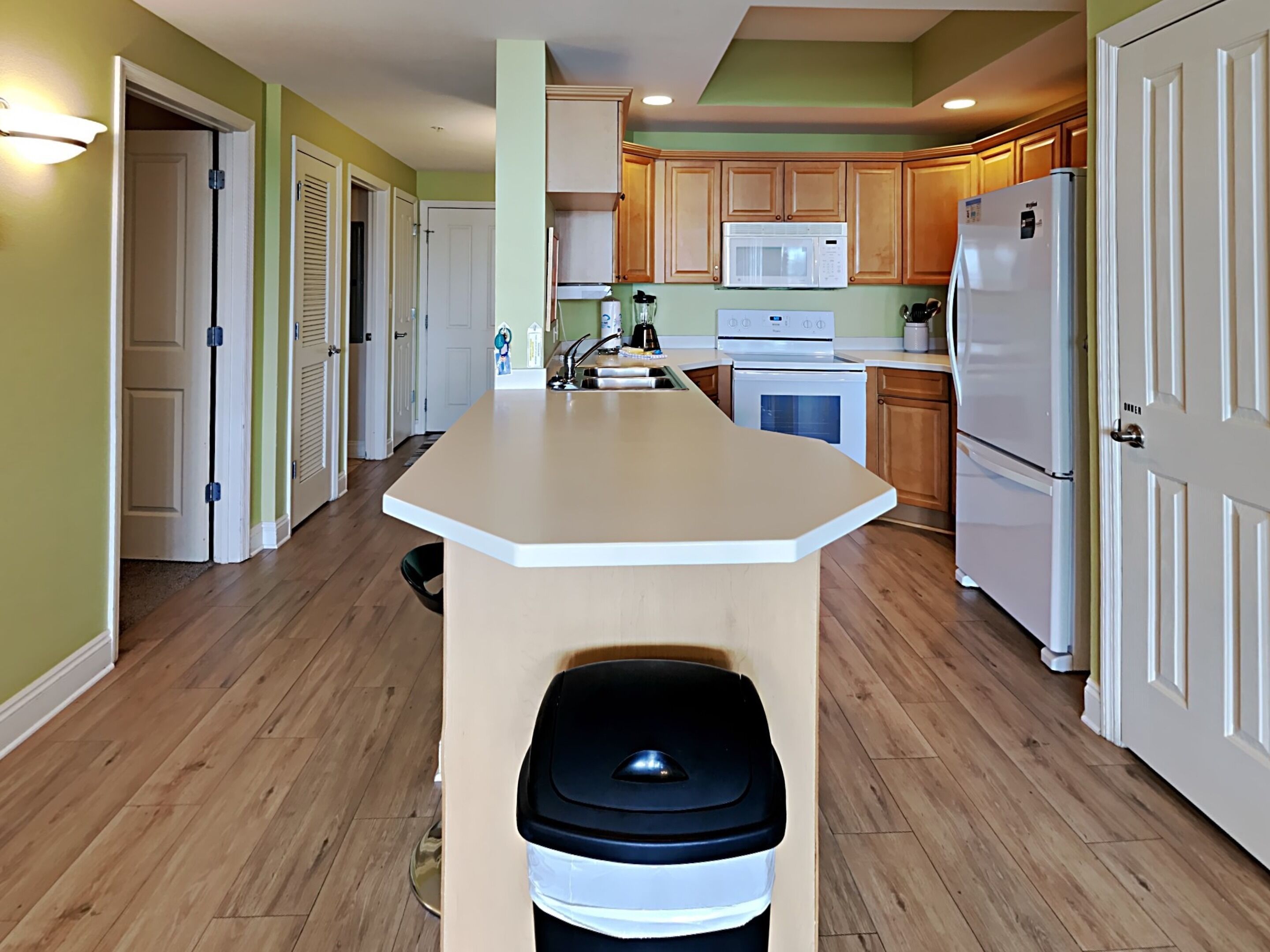 A kitchen with wooden cabinets, a white refrigerator, a microwave, and a stove.