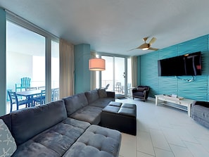 Relax in this stylish room with a large L-shaped sofa, flat-screen TV, and balcony dining area.