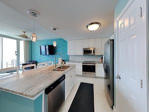 Enjoy cooking in this well-equipped kitchen with a central island, oven, and stainless steel appliances.