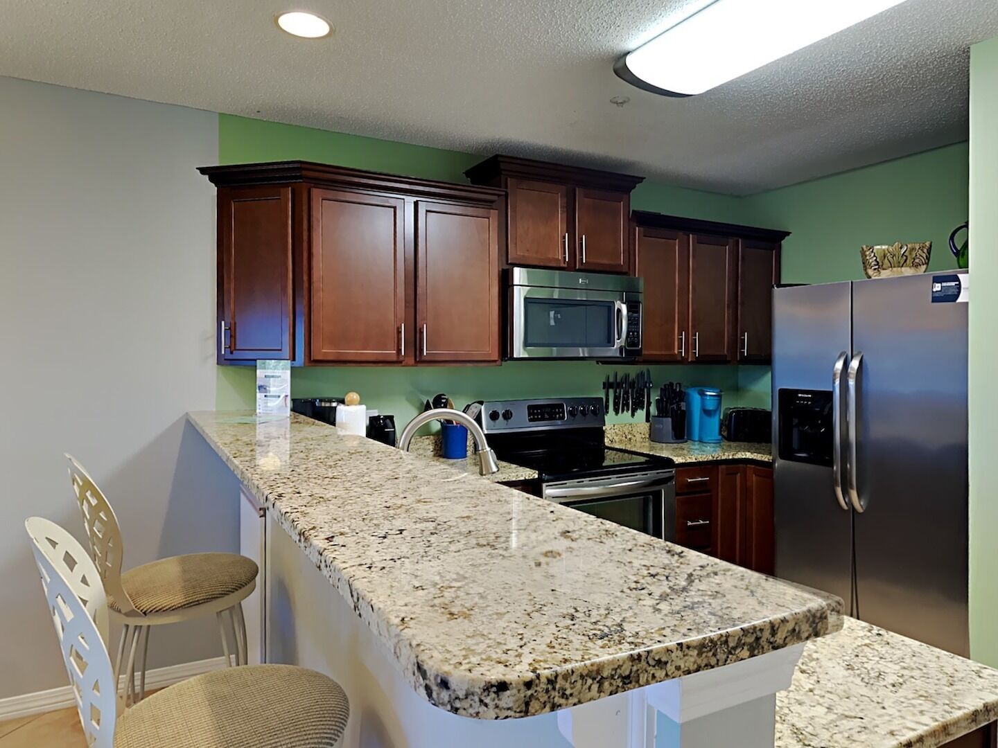 A kitchen with granite countertops, stainless steel appliances, and wooden cabinets.