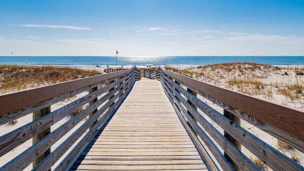 A wooden boardwalk leading to a beach with a red flag indicating no swimming. - Gulf Shores Plantation II by Southern Vacation Rentals (Gulf Shores)